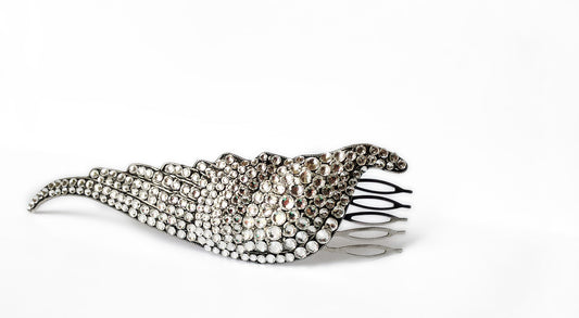 An elegant silver wing shaped hair comb, embellished with shimmering rhinestones.
