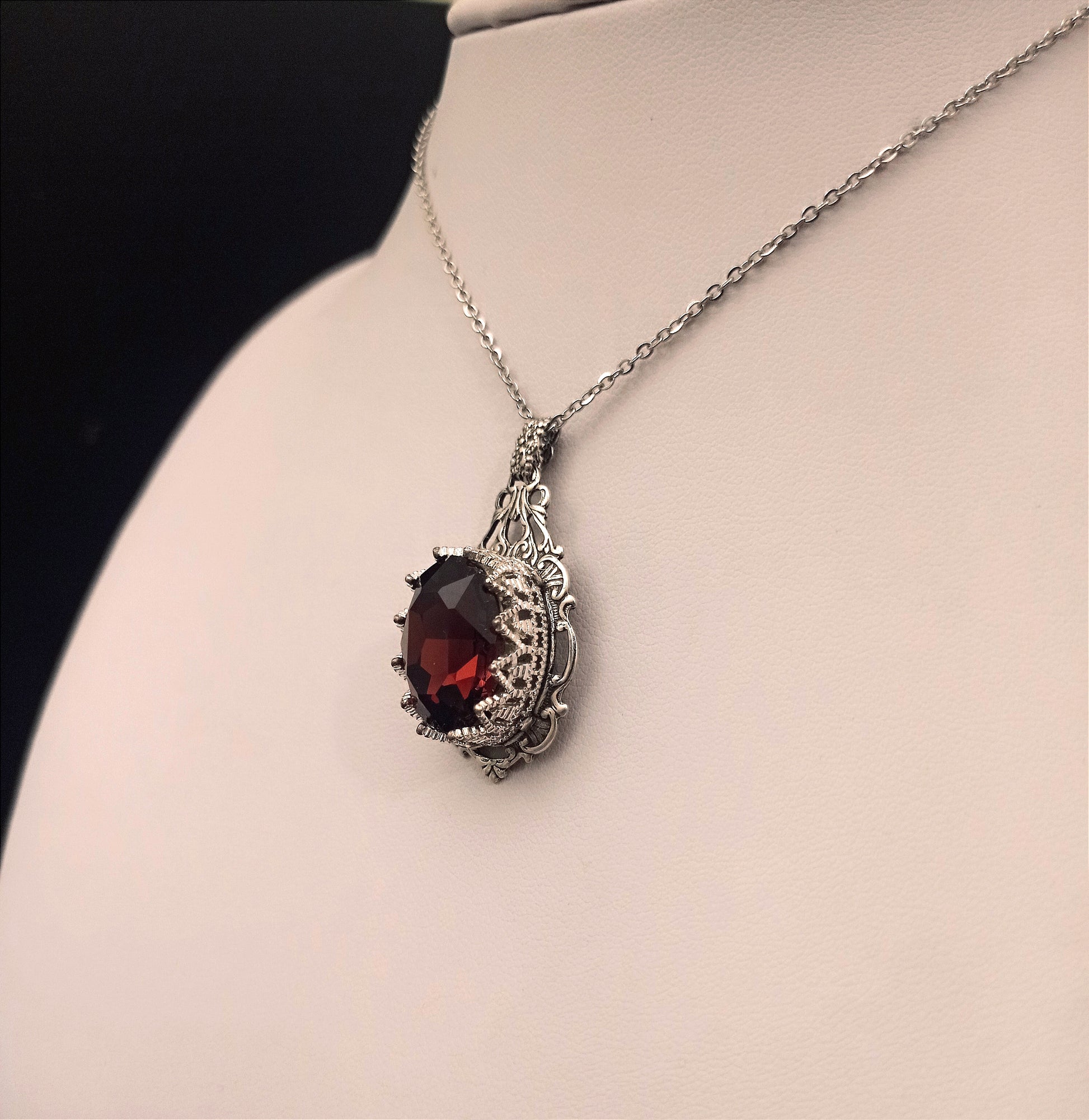 Ornate Victorian Gothic necklace showcasing a beautiful burgundy gem in intricate silver setting.