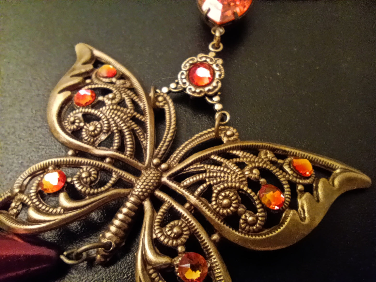 Brass filigree butterfly and red crystals necklace