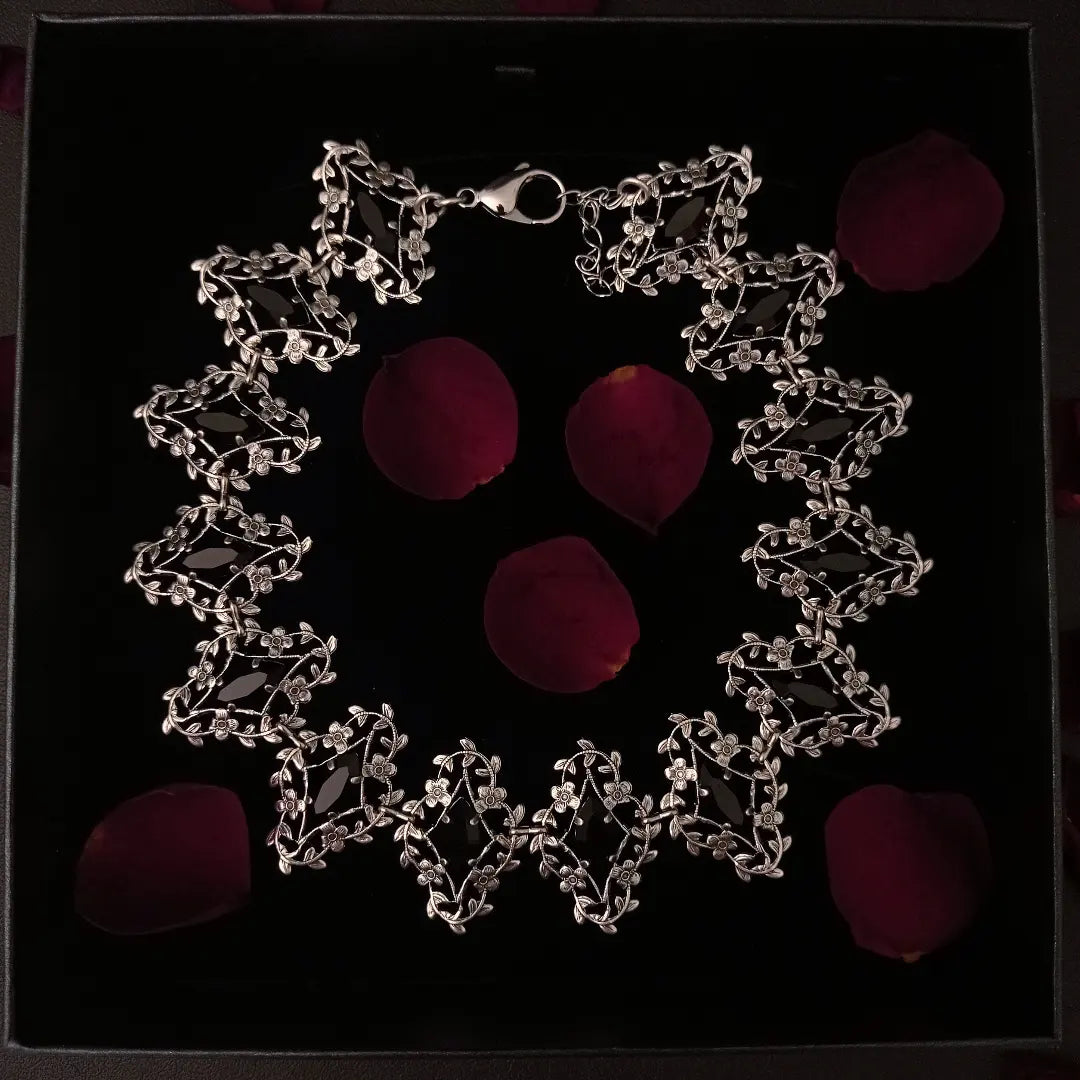 Exquisite silver Victorian Gothic choker necklace with delicate flower and leaves frames that showcase marquis shaped black crystals, radiating elegance and timeless allure.