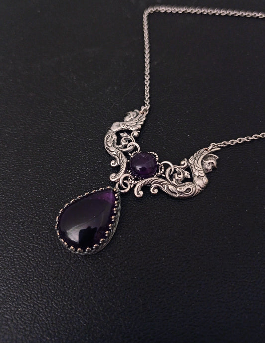 Victorian/Vintage Inspired necklace featuring a beautiful center piece with two winged angels in antique silver supporting two dark purple amethyst cabochons.