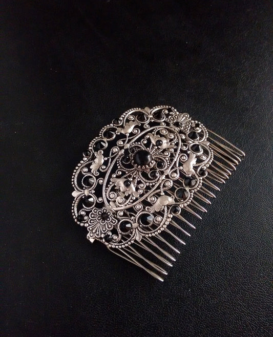 Decorative silver Victorian hair comb featuring intricate filigree designs and black crystal rhinestones, with a focal black onyx cabochon.