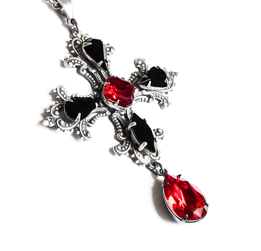 Large silver gothic cross pendant adorned with black and red crystals, featuring intricate detailing.
