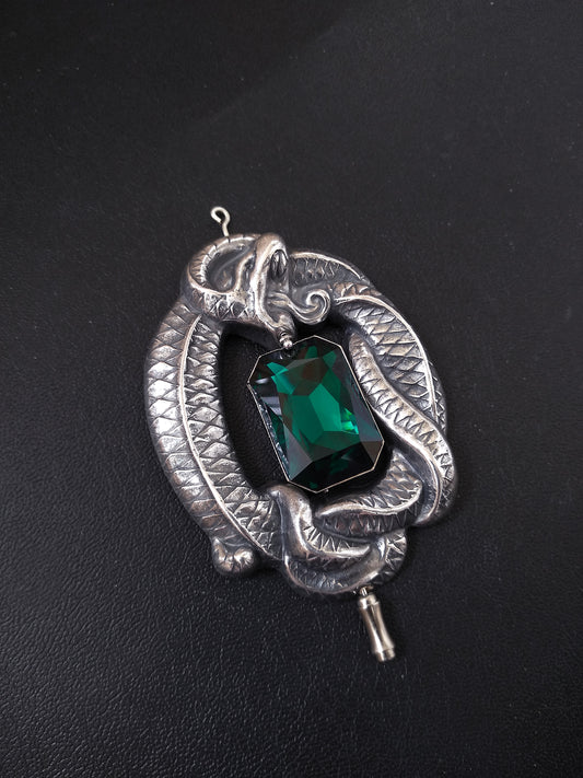 Silver Gothic brooch pin shaped as a large coiled snake with amazing details wrapped around a large Emerald Austrian crystal jewel in octagon shape.