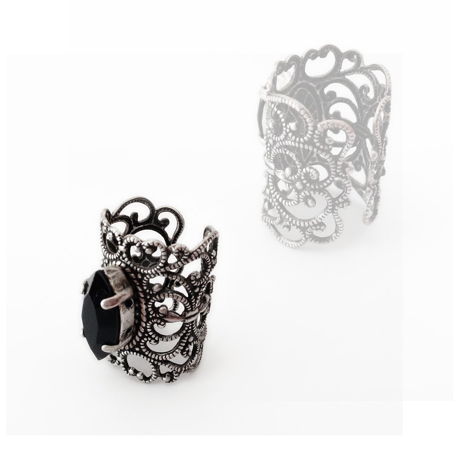 A delicate silver filigree knuckle ring with a jet black Swarovski crystal jewel, shown against a white background.